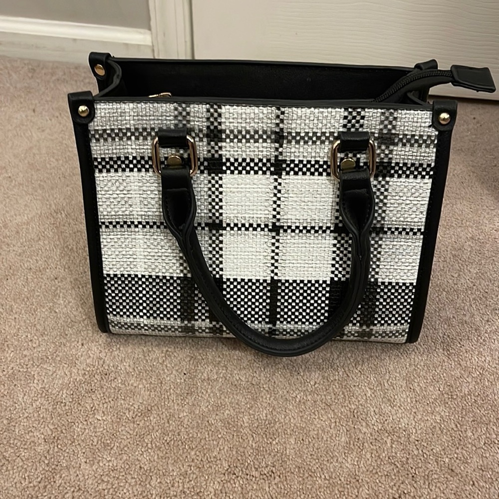 Plaid white and black bag with black zipper. Like new. I don’t have  long strap.